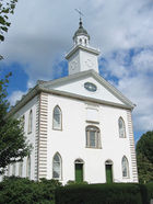 Photo of the Kirtland temple, a white two-story building with a steeple