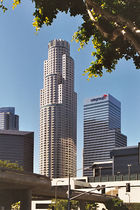 Distant ground-level view of an 80-story building with a circular cross section whitish exterior; the skyscraper has a flat roof and setbacks at many levels.