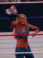 Michelle McCool holds up the WWE Divas Championship belt at the edge of the ring