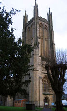 Decorated and buttressed yellow stone tower.