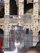 The silver European Champions Clubs' Cup stands in a clear display case in front of the Colosseum