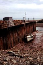 Photo of boat resting on bottom next to dock