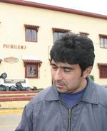 a man in a blue jacket stands on the street