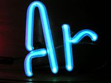 Illuminated blue gas discharge tubes shaped as letters A and r