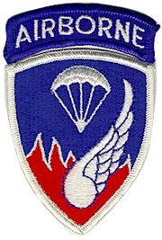 A blue shoulder patch saying "AIRBORNE" and containing images of a parachute and a wing superimposed over fire