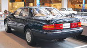 Aft quarter view of sedan on museum display indoors. The license plate says 'Celsior'.