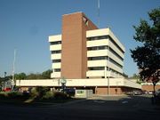 A modern white building with about 5 stories, with a brick center tower