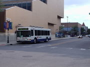 A white low-floor city bus on an empty city street