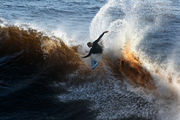 Photo of surfer wiping out with arms outstretched and body parallel to surface