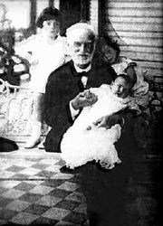 A grey haired man with several small children