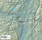 A relief map shows Albany on a flat plain near two rivers, surrounded by mountainous regions.