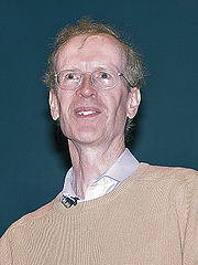 A white man wearing glasses and a shirt looking upward