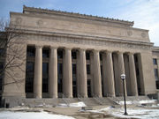 White-colored stone building with columns in the center of the facade