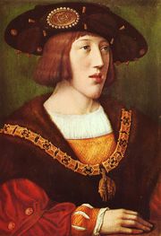 A young noble with brown hair and a long chin, bedecked in fine clothes and a hat.