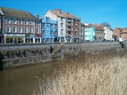 Three and four storey buildings on the far side of a river.