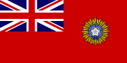 A British Red Ensign (a red flag with the Union Jack placed at the top left corner) charged with the Star of India (five pointed star inside a circular band tied at the bottom)