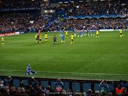 Chelsea (blue) and Barcelona players (yellow) leave the pitch at the end of the first half of their semi-final second leg at Stamford Bridge. The referee is talking to two Barcelona players.