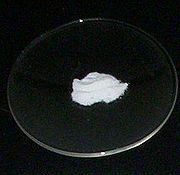 Some fine white powder on a laboratory watch glass