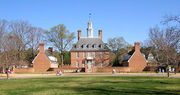 A three story red brick colonial style hall and its left and right wings during winter.