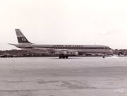 A black and white photograph of a Douglas DC-8 aircraft on the tarmac