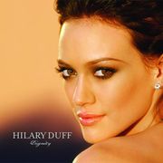 The face and shoulders of a young woman looking over her left shoulder. She has brown hair and wears small crystal earrings. To the left of her image, the words "Hilary Duff" are written in silver, capital letters, with "Dignity" in silver, italic, cursive letters below that.