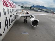 An aircraft painted in white colour, with the airline's name painted in black and red on the fuselage, parkedon the tarmac