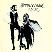 Mostly cream album cover with black-and-white image of tall, bearded gentleman holding the hand of blonde, cape-wearing woman. In the top right-hand corner, it is captioned "FLEETWOOD MAC" and "RUMOURS" below it.