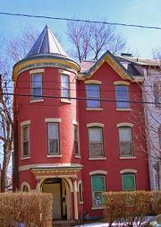 Narrow, red three-story house with turret