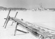 Frozen sea with a dock in front and a ship in behind.