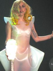 A blond female, holding a lighted-bulb stick. She has yellow curls and wears a translucent white dress.