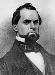 Back and white photo of a bearded man wearing a suit