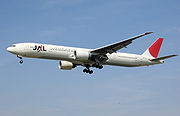 Aircraft landing approach. Side view of twin-engine jet in flight with flaps and landing gear extended, with extended and raked wingtips.