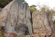 Five Buddhas carved into two natural rocks.