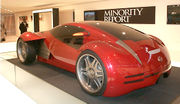 Futuristic two-door concept car displayed in front of a banner labeled 'Minority Report.'