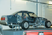 Sedan cutaway on museum display, showing trunk space, chassis, cabin, and engine bay. The aft emblem says 'Lexus'.