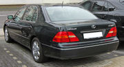 Rear quarter view of sedan parked next to an SUV. The vehicle nameplate says 'Lexus' and 'LS 430'.