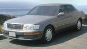 Front quarter view of sedan parked outdoors, with seaside background.