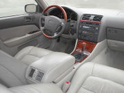 Automobile front interior, showing center armrest, front seat cushions, console, and dashboard.