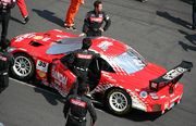 Overhead view of a racecar surrounded by personnel.