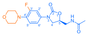 Skeletal formula of N-{[(5S)-3-[3-fluoro-4-(morpholin-4-yl)phenyl]-2-oxo-1,3-oxazolidin-5-yl]methyl}acetamide, highlighting the morpholino and fluoro groups in orange, with the rest in blue. The carbon atoms of the parent chain are numbered.