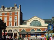 External view of the museum, a red brick building with a glass roof; the name of the museum curves around the top of a large semi-circular window