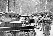 A group of soldiers, including several high-ranking officers, observe a Tetrarch light tank