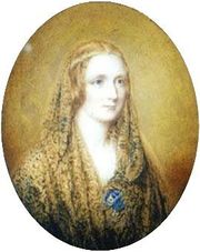 Oval portrait of a woman wearing a shawl and a thin circlet around her head. It is painted on a flax colored background.