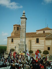 People celebrating and waving flags around an altar-like table with flowers.