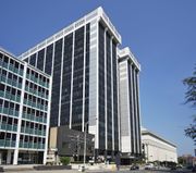 A tall, white, steel-framed building with black windows.