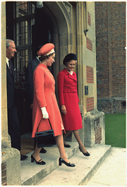 Elizabeth and Pat Nixon walk out of a red-brick building in step