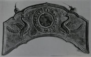 Flat metal sheet in an arc shape  with embossed relief of two birds.