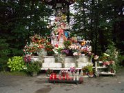 A statue, covered with flowers.