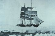  Three masted ship with sails spread, surrounded by pack ice, with a narrow lane of water in the foreground