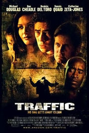 Movie poster with five people shown from the neck up. The man on the left has his pointer finger pressed against his lips; the woman to his right has long hair and is smiling; the three man at the right have grim looks as they stare to the right. Below them are several vehicles and a man holding a gun that is getting shot. The top of the image includes the starring credits, while the bottom includes the title of the film and the main credits.